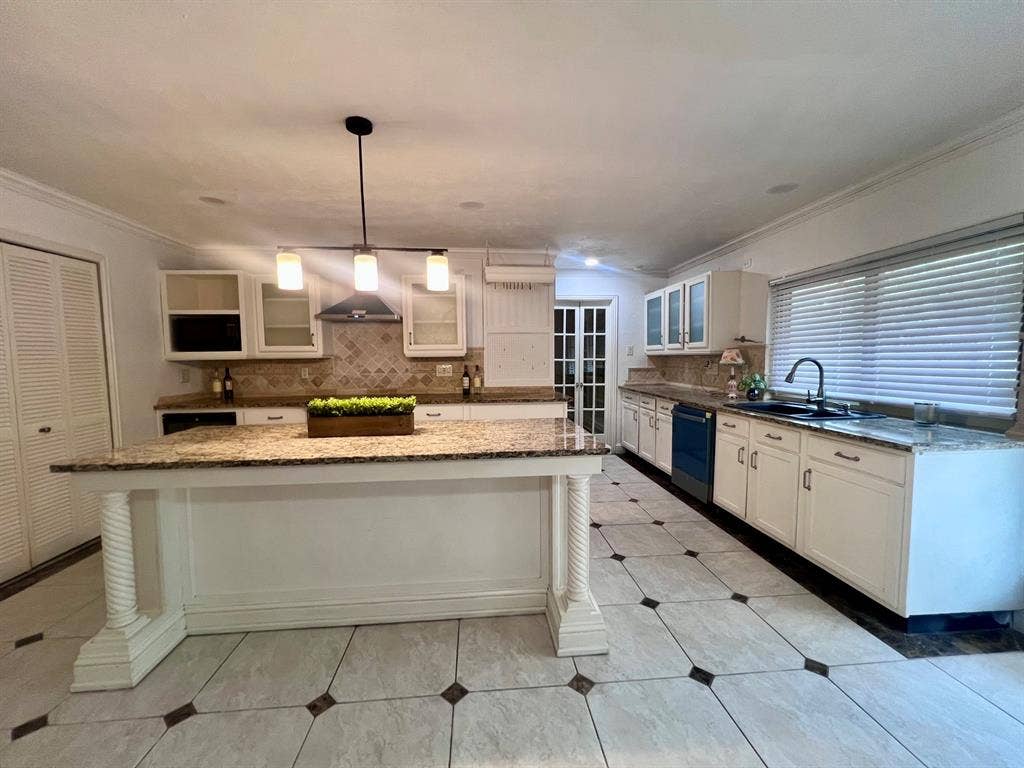 3925 Villa Downs Drive, Plano, TX 75023 Kitchen island with granite countertop, tiled flooring, white cabinetry, dark appliances, and a modern pendant light fixture
