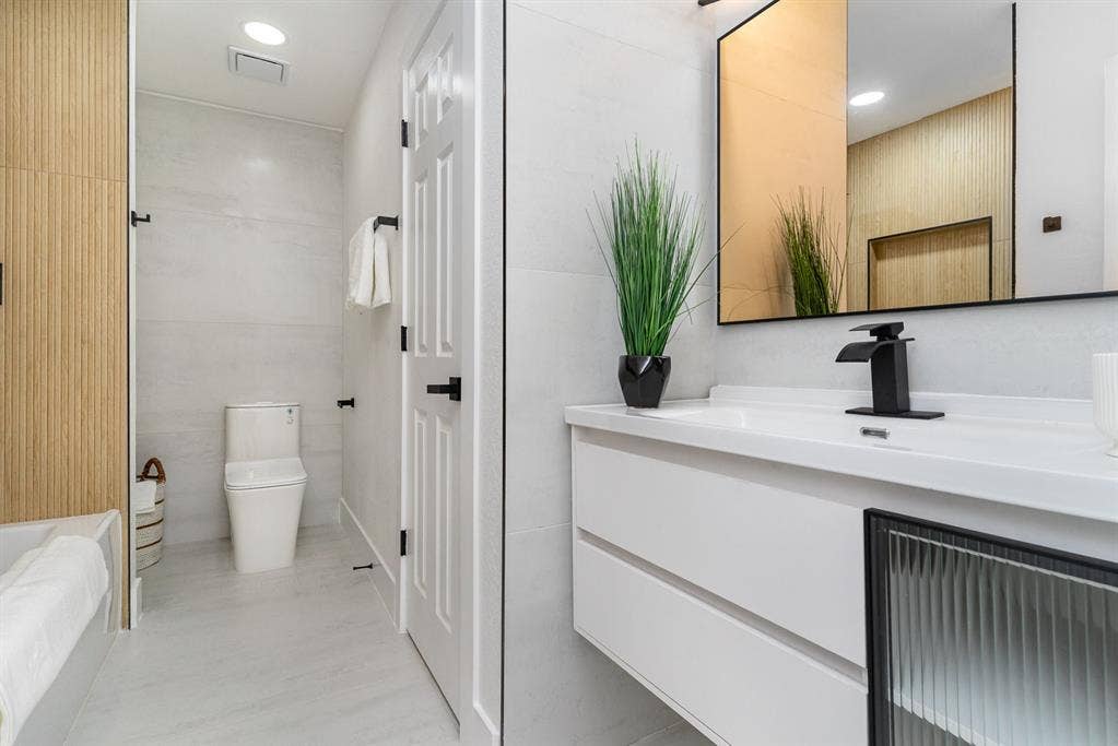 17732 Windflower Way, Dallas, TX 75252 Bathroom with tile walls, vanity, and toilet