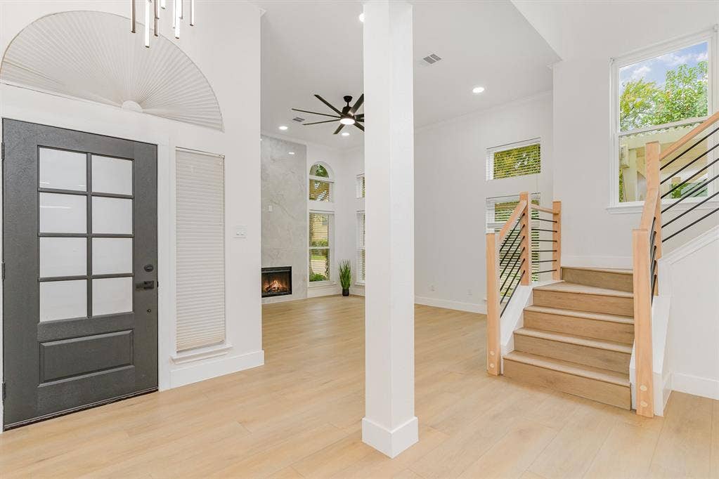 17732 Windflower Way, Dallas, TX 75252 Entrance foyer featuring a high ceiling, a premium fireplace, and light hardwood / wood-style flooring