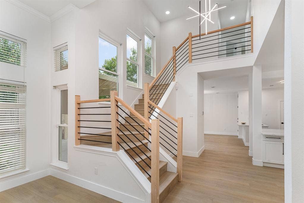 17732 Windflower Way, Dallas, TX 75252 Stairway featuring a towering ceiling, hardwood / wood-style floors, and plenty of natural light