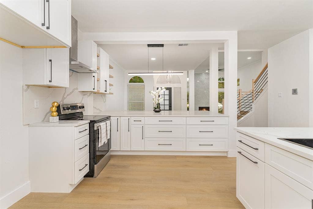 17732 Windflower Way, Dallas, TX 75252 Kitchen featuring pendant lighting, light wood-type flooring, white cabinetry, and stainless steel electric stove