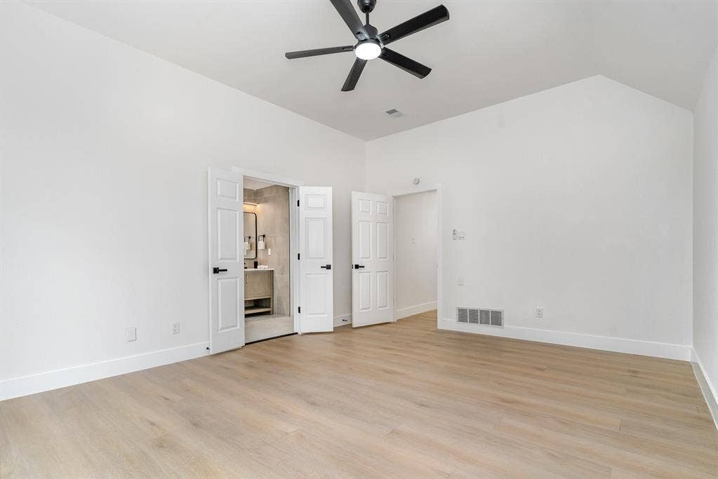 17732 Windflower Way, Dallas, TX 75252 Unfurnished bedroom featuring ensuite bathroom, high vaulted ceiling, light hardwood / wood-style flooring, and ceiling fan