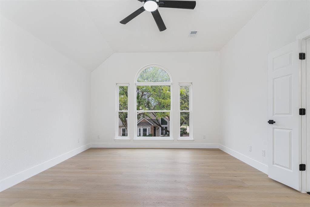 17732 Windflower Way, Dallas, TX 75252 Empty room featuring ceiling fan, lofted ceiling, and light hardwood / wood-style floors