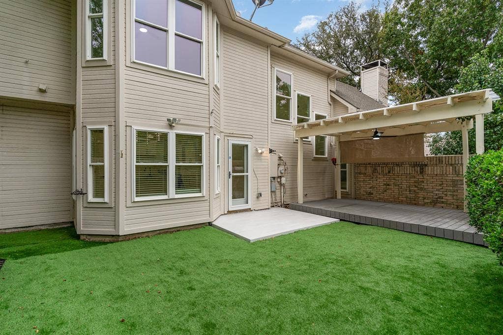 17732 Windflower Way, Dallas, TX 75252 Back of property with a lawn and a patio area