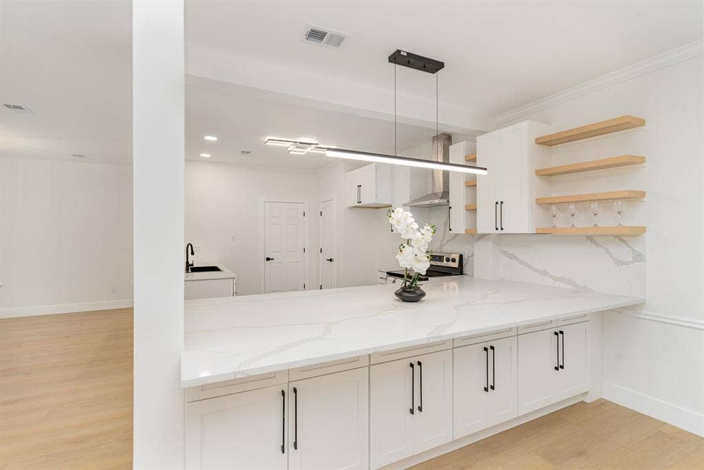 17732 Windflower Way, Dallas, TX 75252 Kitchen with light stone counters, white cabinets, stainless steel electric stove, pendant lighting, and light wood-type flooring