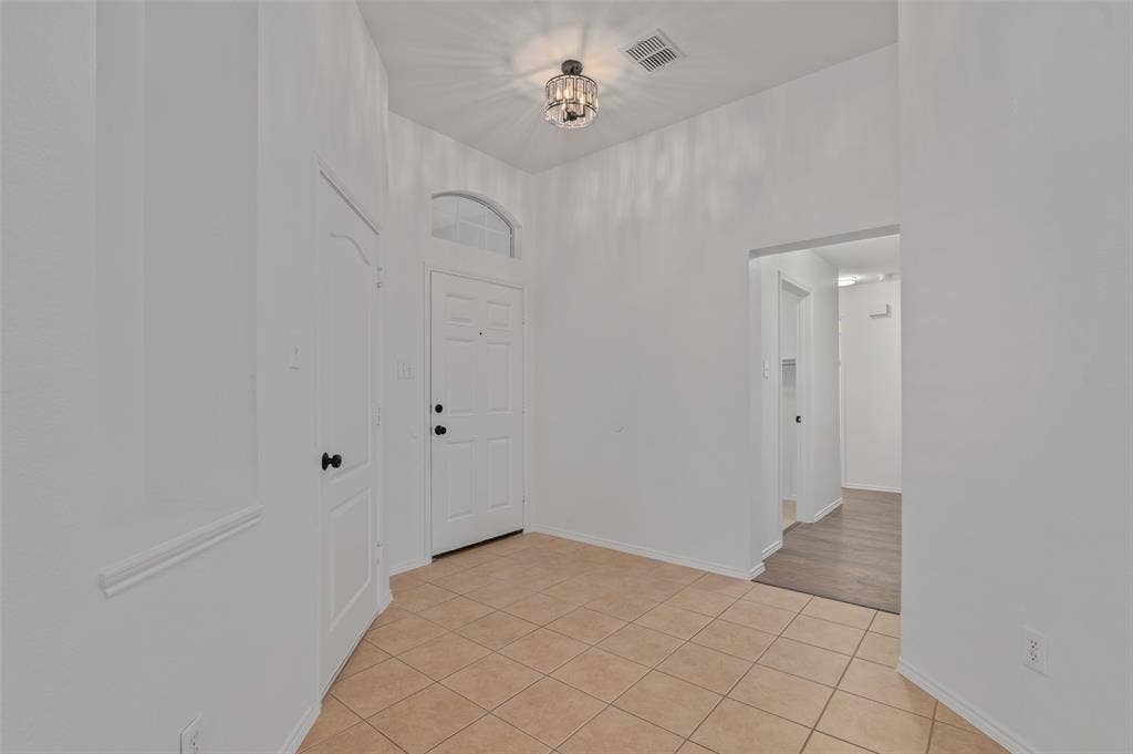 2809 Hollow Ridge Drive, Denton, TX 76210 Entry with view of front door and hallway to secondary bedrooms and the utility room