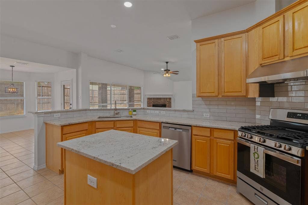 2809 Hollow Ridge Drive, Denton, TX 76210 This refreshed and open kitchen space provides ample storage space and an open feel as it looks out over a wall of windows in the breakfast nook and living room.