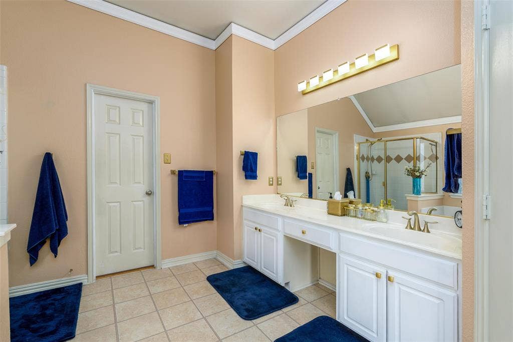 5800 Pine Ridge Boulevard, McKinney, TX 75070 An ensuite primary bath with dual sinks and separate shower and whirlpool bath.