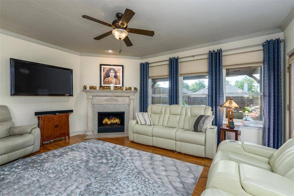 5800 Pine Ridge Boulevard, McKinney, TX 75070 The living area has a fireplace and large windows for plenty of natural light.