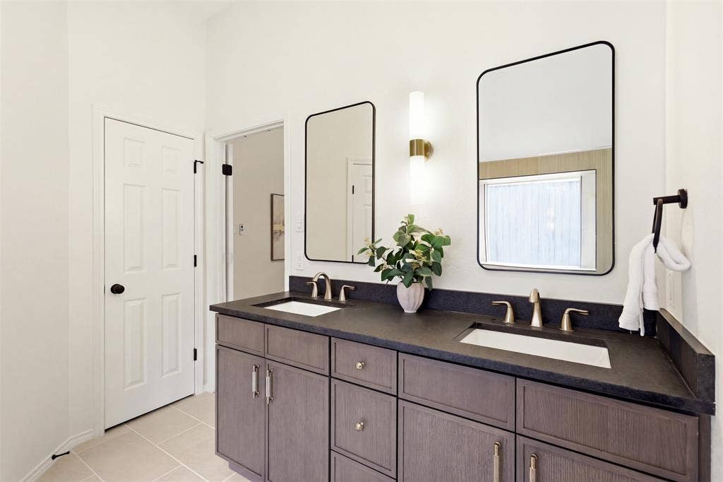 Double vanity with dark wood-finish cabinetry and dual undermount sinks