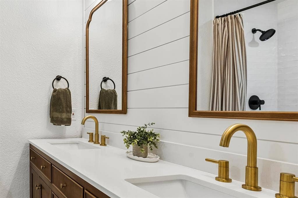 4021 Overdowns Drive, Plano, TX 75023 The primary bath's brand-new double vanity pairs brass fixtures with all-new mirrors and lighting.