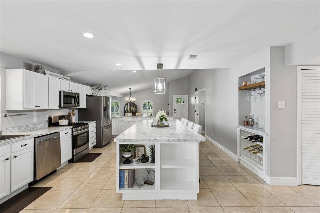 4021 Overdowns Drive, Plano, TX 75023 A custom bar area with a built-in wine glass rack turns the kitchen's edge into its own entertaining station.