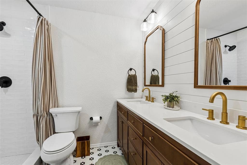 4021 Overdowns Drive, Plano, TX 75023 The hall bath's tub-and-shower combo, finished in white subway tile, serves both secondary bedrooms.
