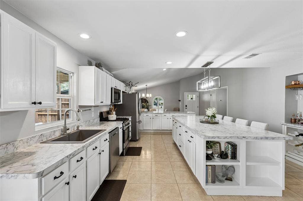 4021 Overdowns Drive, Plano, TX 75023 Storage that works as hard as the cooktop — open shelving built into the island keeps cookbooks and extras within reach.