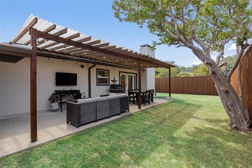 4021 Overdowns Drive, Plano, TX 75023 Privacy fencing wraps the full yard, with plenty of open grass beyond the covered patio.