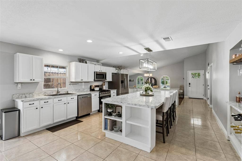 4021 Overdowns Drive, Plano, TX 75023 White cabinetry and quartz-look counters run the full length of the kitchen, with sightlines clear to the front door.