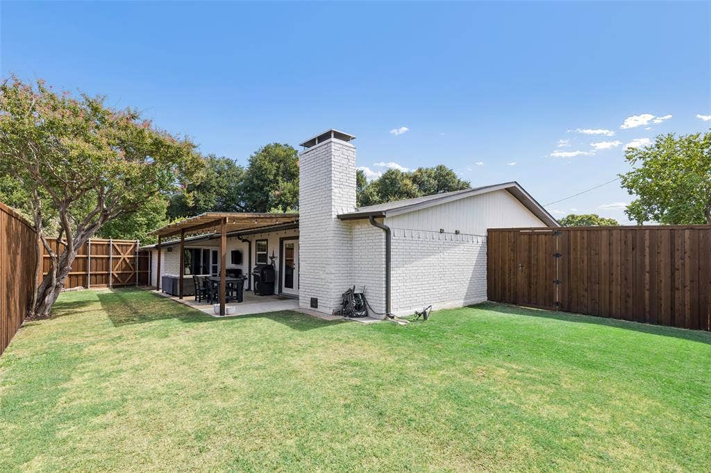 4021 Overdowns Drive, Plano, TX 75023 The painted brick exterior extends around back, with a gated side yard for extra storage or access.