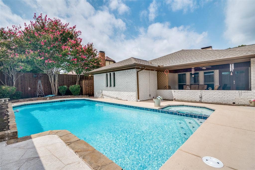 3632 Candelaria Drive, Plano, TX 75023 Swimming pool with integrated spa, concrete decking, wood fencing, and mature flowering trees