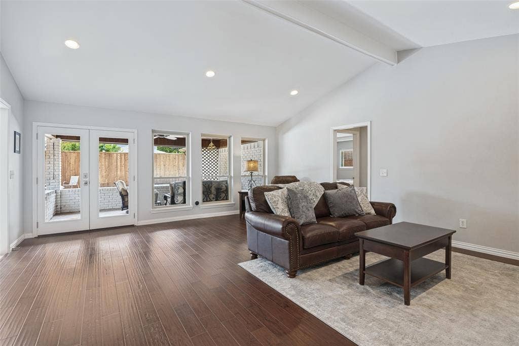 3632 Candelaria Drive, Plano, TX 75023 Wood-finish flooring throughout, vaulted ceiling, recessed lighting, and white French doors leading to a brick patio