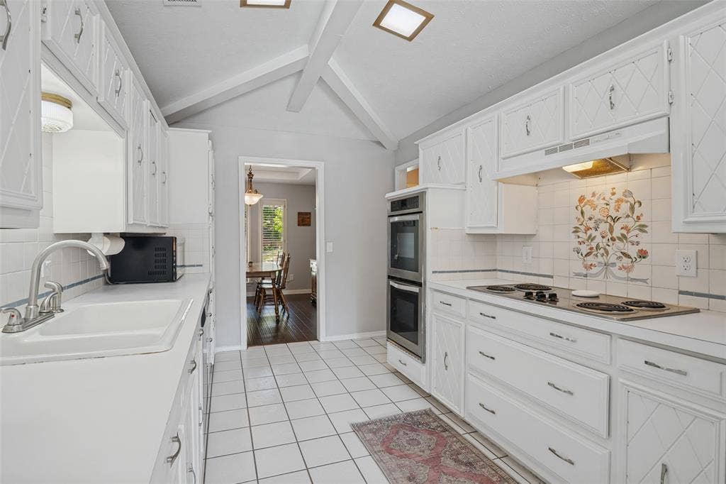 3632 Candelaria Drive, Plano, TX 75023 Galley kitchen featuring white cabinetry, tile flooring, built-in double oven, and an electric cooktop