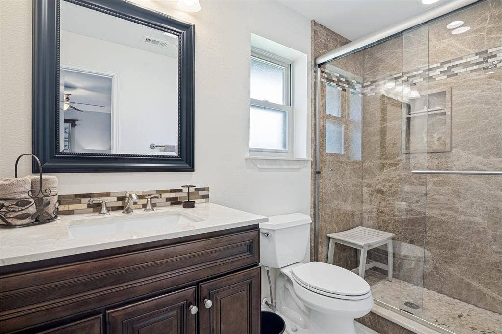 3632 Candelaria Drive, Plano, TX 75023 Dark wood-finish vanity with a white countertop and rectangular sink