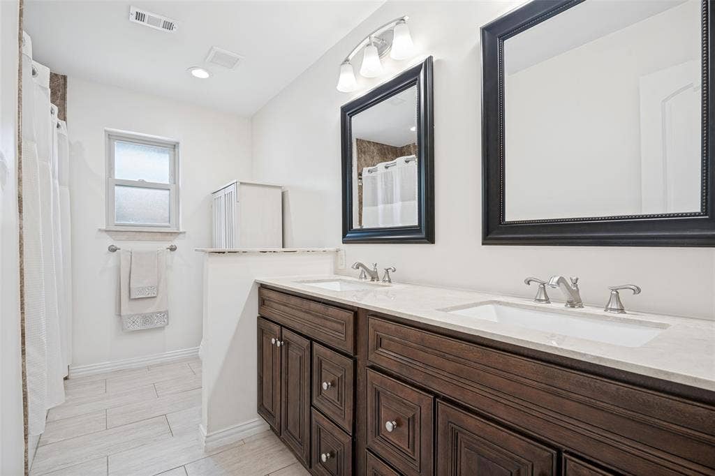 3632 Candelaria Drive, Plano, TX 75023 Double vanity with wood-finish cabinetry and light-toned countertops