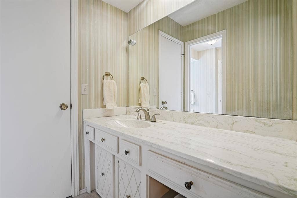 3632 Candelaria Drive, Plano, TX 75023 Vanity with an integrated sink, brushed nickel faucet, light-toned countertop, and white cabinetry with dark hardware