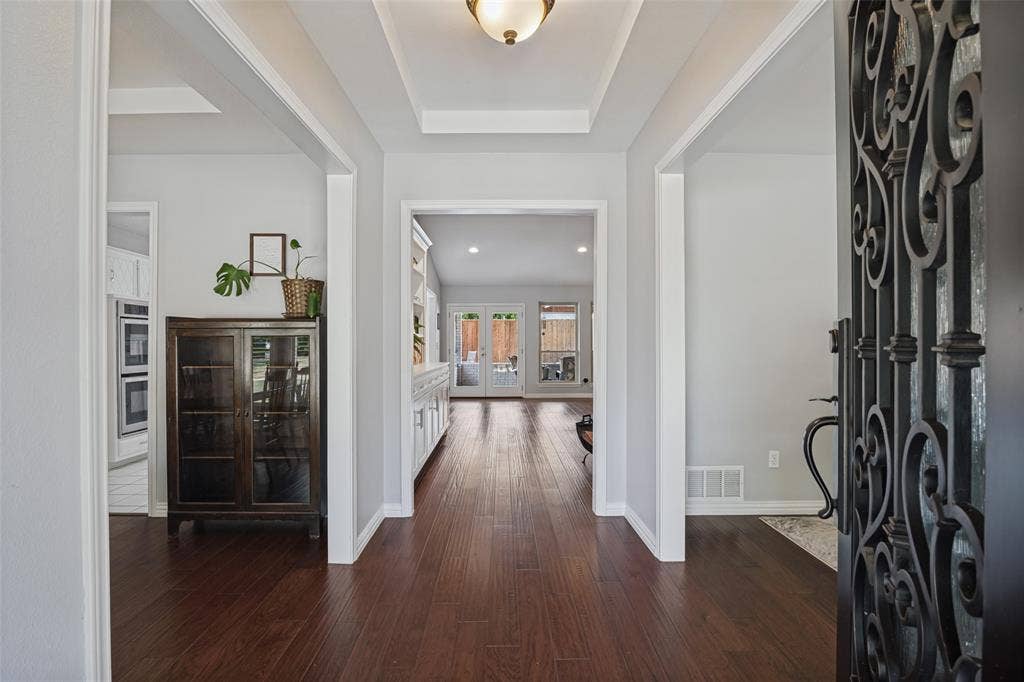 3632 Candelaria Drive, Plano, TX 75023 Entryway with dark wood-finish flooring, white trim, and a tray ceiling