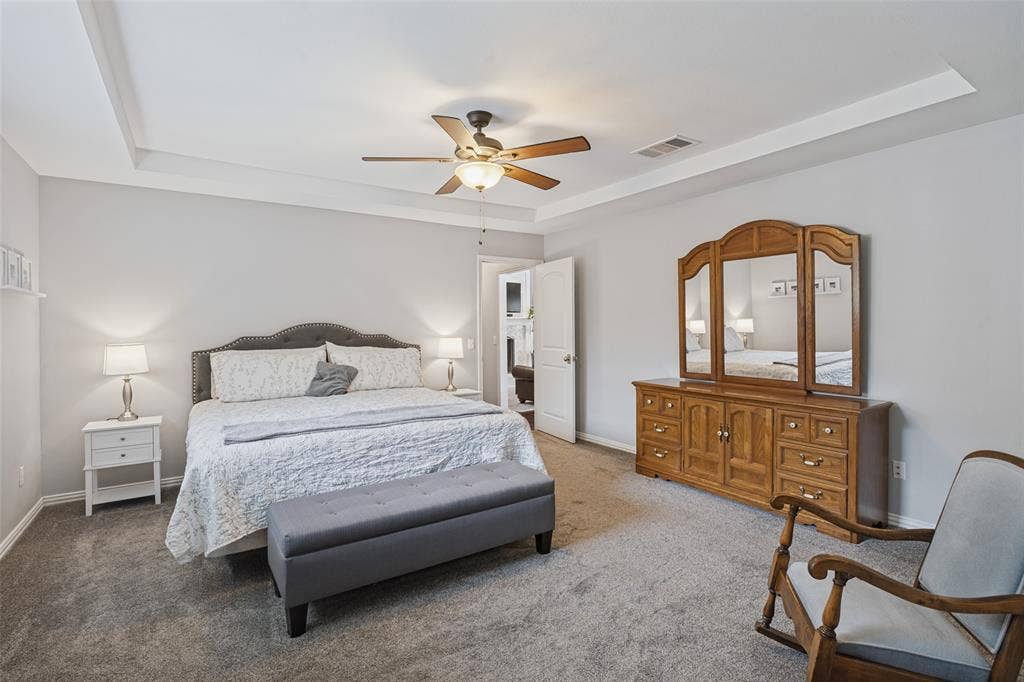 3632 Candelaria Drive, Plano, TX 75023 Spacious primary bedroom featuring a tray ceiling with recessed lighting and ceiling fan, carpeted flooring, and abundant natural light from multiple windows