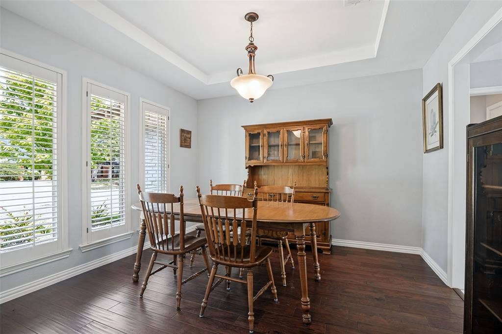 3632 Candelaria Drive, Plano, TX 75023 Hardwood-style flooring with white trim, a tray ceiling, and a prominent chandelier