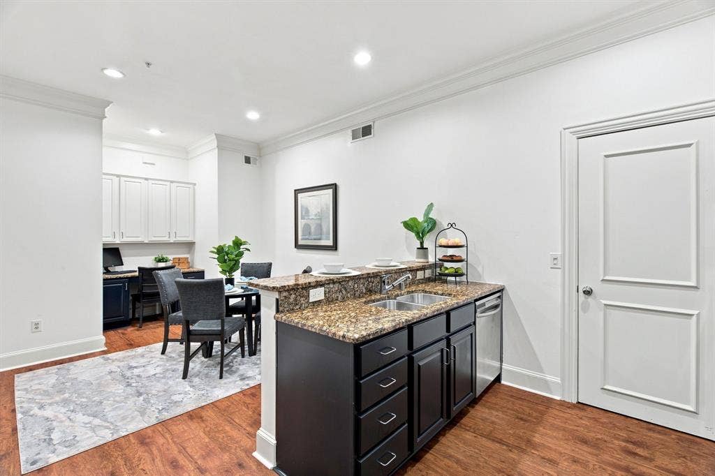 3303 Blackburn Street, #306, Dallas, TX 75204 Kitchen featuring dark wood-finish cabinetry, a dual basin stainless steel sink, and a dishwasher