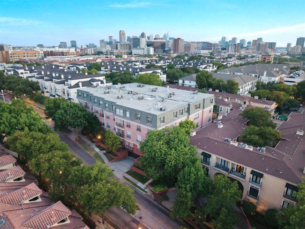 3303 Blackburn Street, #306, Dallas, TX 75204 Aerial perspective showcasing multiple residential buildings, including a prominent pink-hued structure with multiple balconies and a mansard-style roof