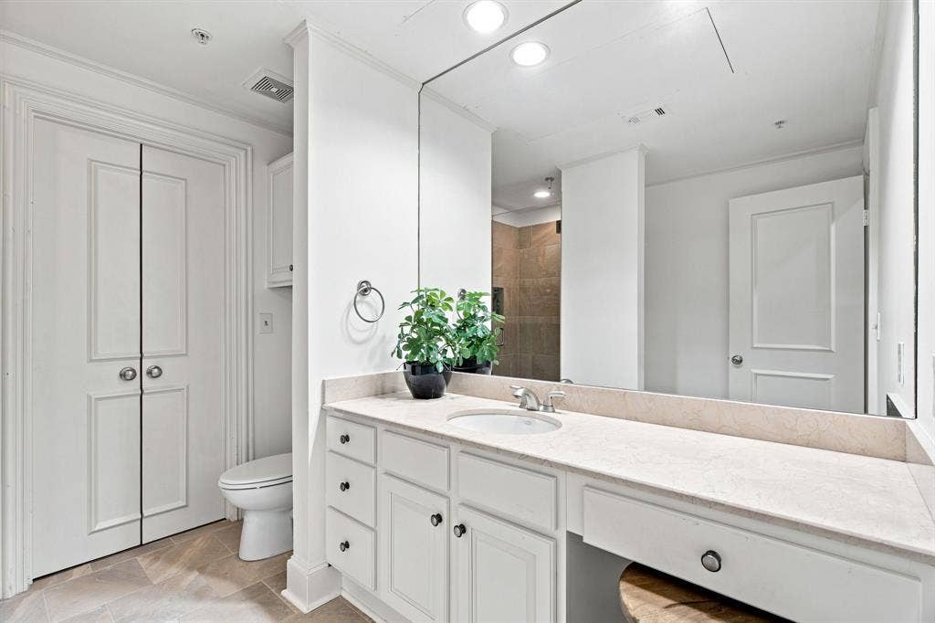 3303 Blackburn Street, #306, Dallas, TX 75204 Dual-sink vanity with light-toned countertop, built-in cabinetry, and tile flooring