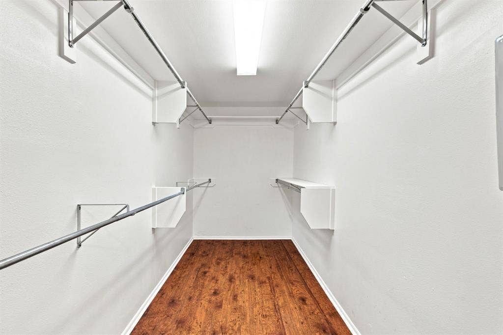 3303 Blackburn Street, #306, Dallas, TX 75204 Walk-in closet featuring wood-finish flooring, white walls, built-in shelving, and metal hanging rods