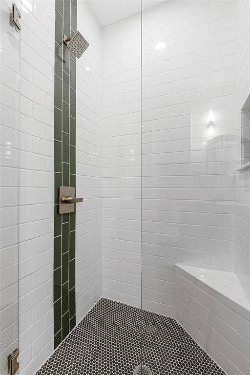 Bathroom with a tile shower and tile patterned flooring