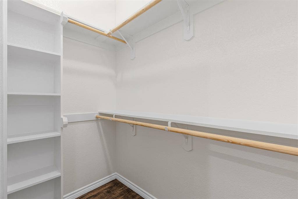 Spacious closet with dark wood finished floors