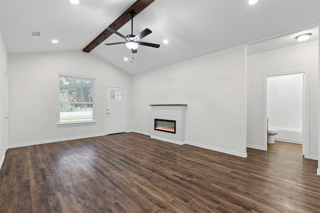 Unfurnished living room with a glass covered fireplace, dark wood finished floors, ceiling fan, recessed lighting, and baseboards