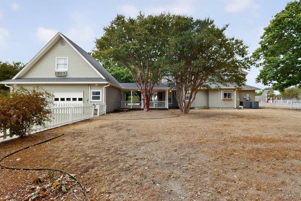 2 Trailridge Drive, Melissa, TX 75454 Exterior siding with an attached garage, featuring a white picket fence, a covered walkway, and mature trees