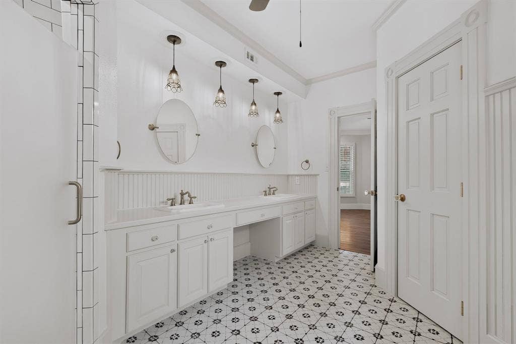 2 Trailridge Drive, Melissa, TX 75454 Spacious bathroom featuring a dual vanity with white cabinetry, patterned floor tiling, and a shower enclosure with subway tile