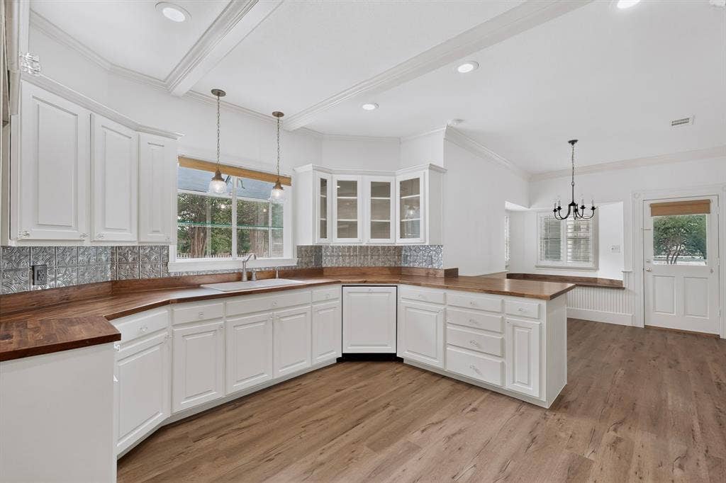 2 Trailridge Drive, Melissa, TX 75454 White shaker-style cabinetry with wood-finish countertops, stainless steel sink, and a patterned backsplash