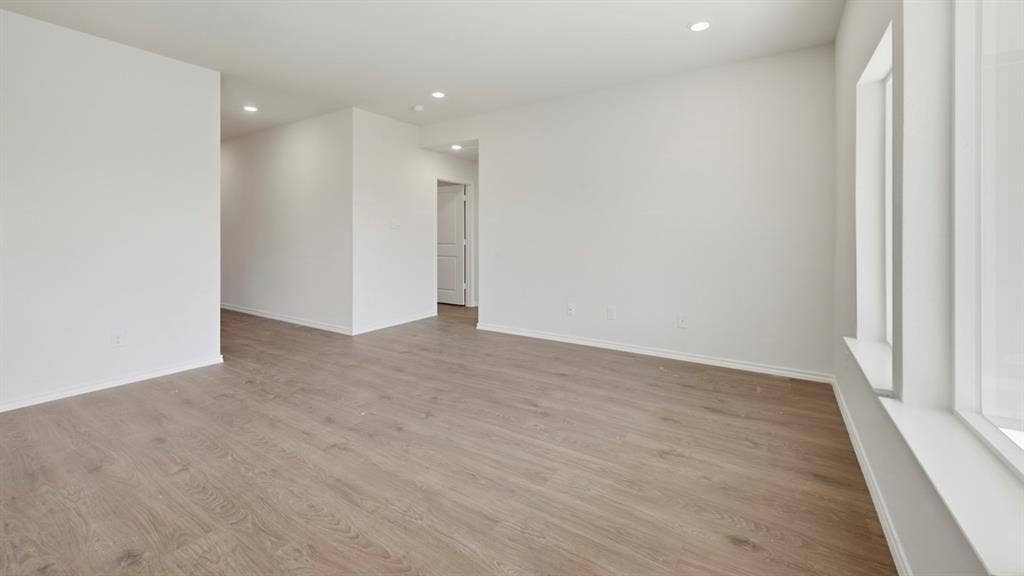 1972 Freeman Street, Tyler, TX 75704 Spacious room featuring wood-finish flooring, recessed lighting, white walls, and large windows with white trim