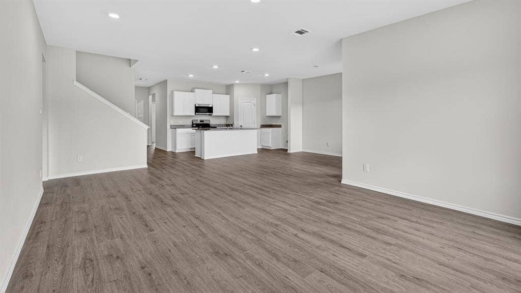 1920 Freeman Street, Tyler, TX 75704 Expansive open-concept living area featuring wood-finish flooring, recessed lighting, and a neutral wall palette