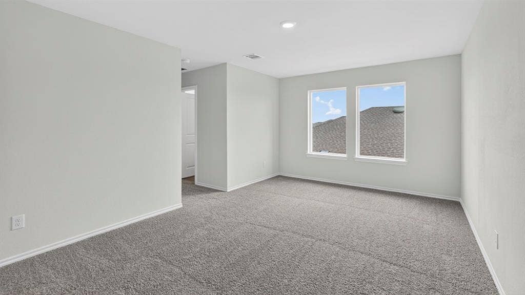 1920 Freeman Street, Tyler, TX 75704 Spacious room with plush gray carpeting, neutral wall color, and two large windows providing natural light