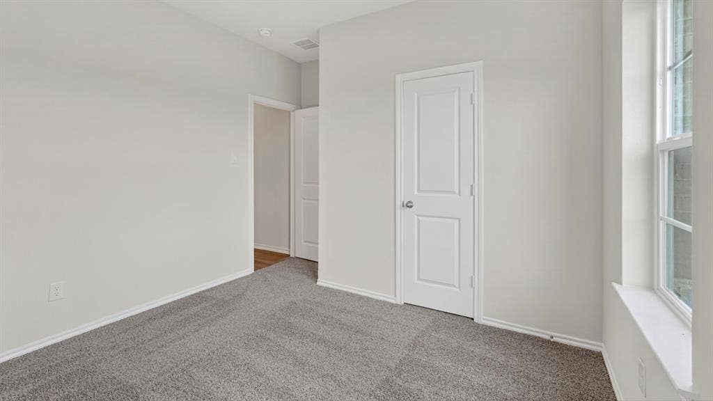 1920 Freeman Street, Tyler, TX 75704 Carpeted interior room featuring light gray walls, white trim, a single window, and a paneled door