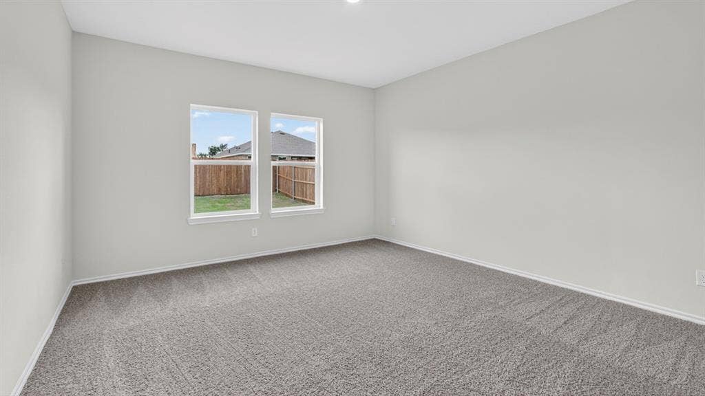 1920 Freeman Street, Tyler, TX 75704 Spacious room featuring neutral carpeting, light gray wall paint, and two double-hung windows