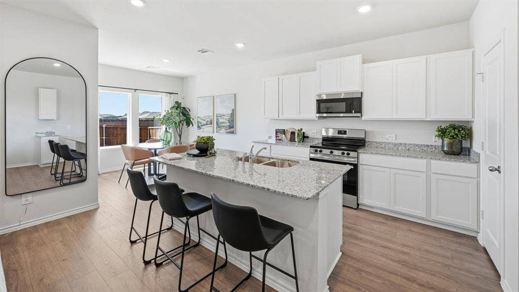 1932 Freeman Street, Tyler, TX 75704 Kitchen featuring an island with stone countertop, stainless steel sink, and seating for three