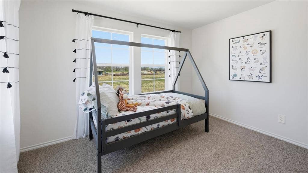 1932 Freeman Street, Tyler, TX 75704 Light-filled room featuring two windows, neutral wall tones, textured carpeting, and white baseboards