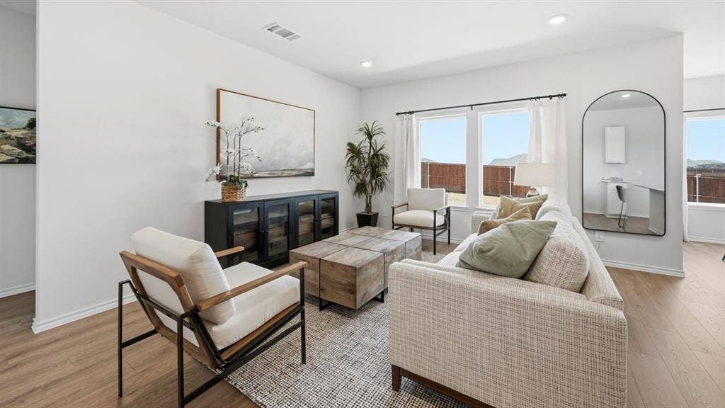 1932 Freeman Street, Tyler, TX 75704 Spacious living area featuring light-tone wood-finish flooring, recessed lighting, and multiple large windows with white trim