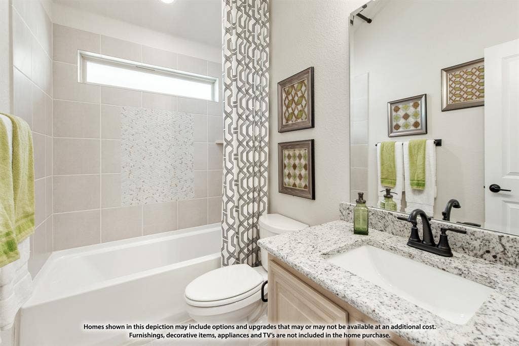 942 Cardinal Drive, Midlothian, TX 76065 Bathtub with tiled surround, transom window, granite-style countertop, undermount sink, and dark-finish fixtures