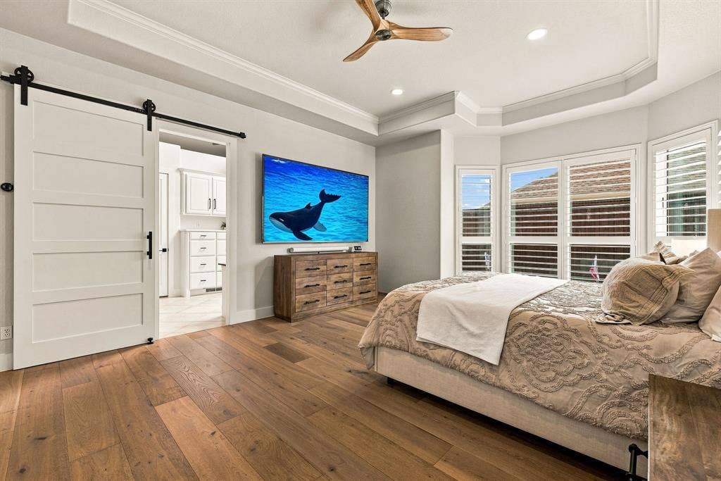 5941 Tiburon Drive, Plano, TX 75093 Wood-finish flooring throughout, featuring a tray ceiling with a ceiling fan